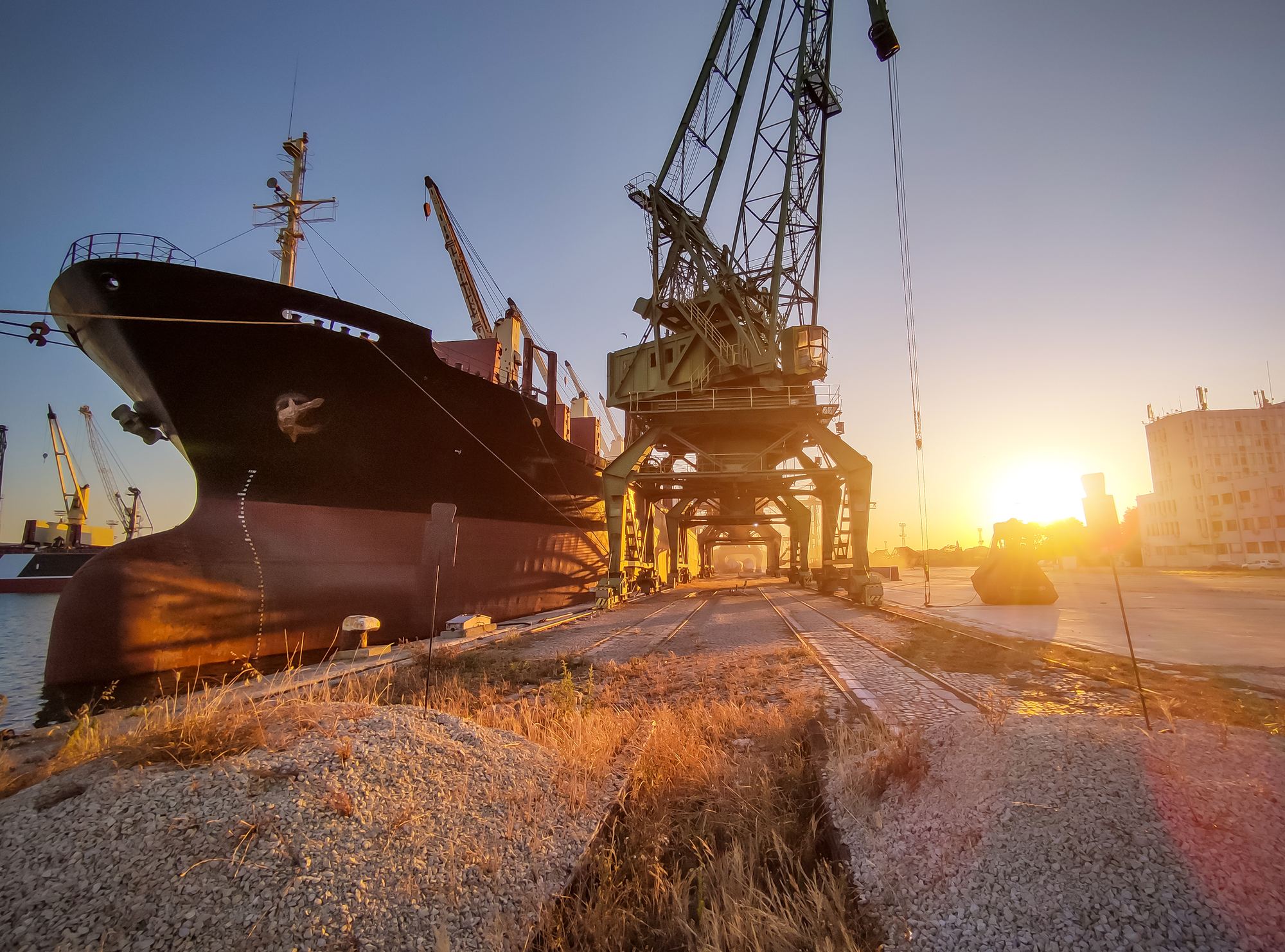 Cargo ship loaded with grain at sunset in port