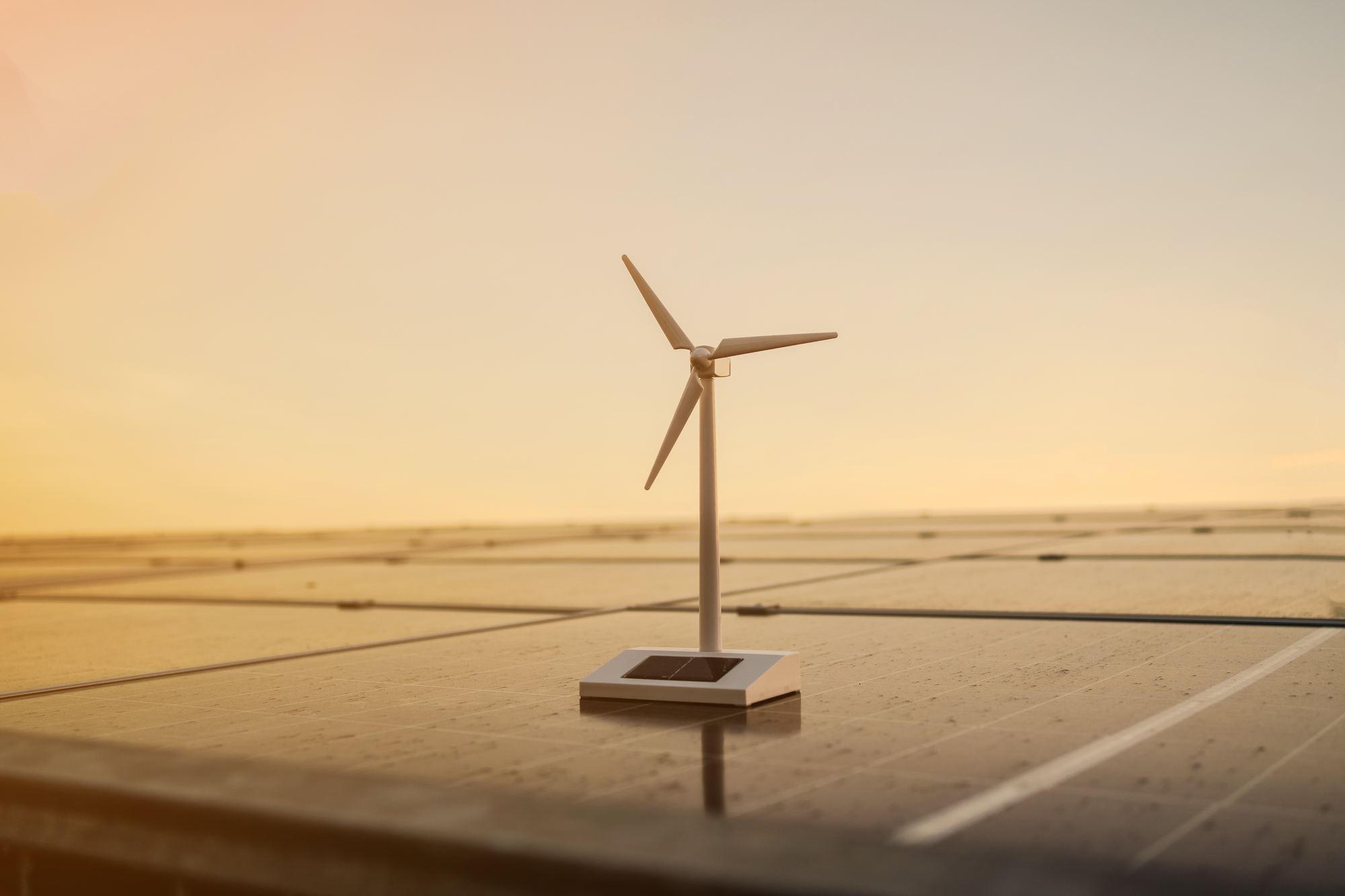 Wind turbine and solar panels at sunset