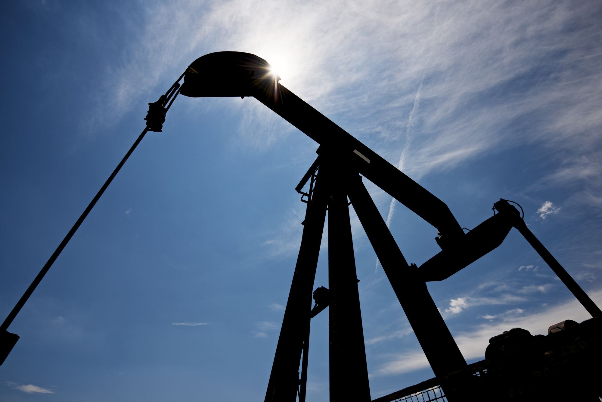 Pumpjack against blue sky, crude oil extraction